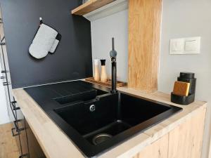 a kitchen with a black sink and a black wall at spacious modern LOFT, 2 bedrooms, 95m2, free parking in Bratislava