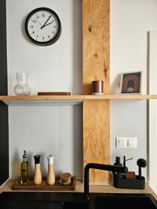 a clock on a wall above a kitchen sink at spacious modern LOFT, 2 bedrooms, 95m2, free parking in Bratislava +17 photos