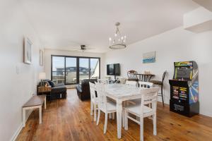 a dining room and living room with a table and chairs at Beach Paradise - Perfect Ocean Sunset Views with Pool & Sauna & Breakfast! in Mexico Beach
