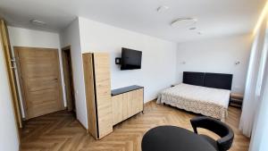 ein kleines Schlafzimmer mit einem Bett und einem Fernseher in der Unterkunft Svečių namai "Robeda House" in Kybartai