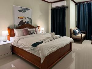a bedroom with a large bed and a chair at Vanida Hotel in Vientiane