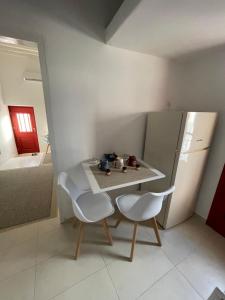 a kitchen with a table and two chairs and a refrigerator at B Collection in Skiros