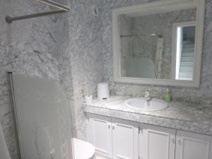 Un baño con lavabo, espejo e inodoro. en Duplex with sea view, en Roquetas de Mar 38 fotos más