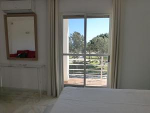 Un dormitorio con una cama y un espejo y una ventana. en Duplex with sea view, en Roquetas de Mar