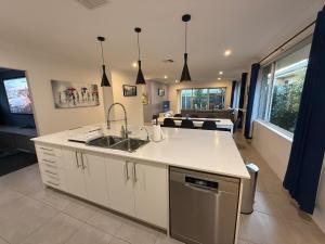 a kitchen with a sink and a living room at The Patricia in The Vines