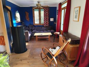 a living room with a couch and a table at Petite chambre in Aigueblanche