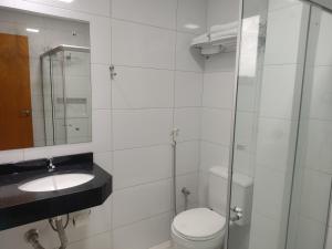a bathroom with a toilet and a sink and a mirror at Hotel e Restaurante La Carreta in Tangara da Serra