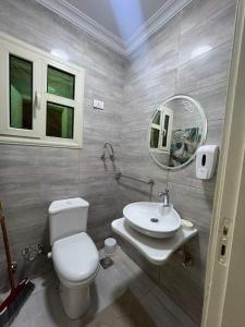 a bathroom with a toilet and a sink and a mirror at شقه سوبر لوكس مفروش in Ṭalkha