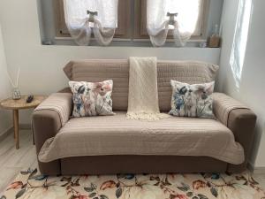 a brown couch with pillows in a living room at Casa Manila Isola d'Elba in Portoferraio