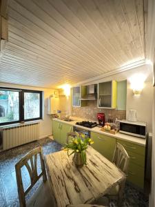 a kitchen with a wooden table with a vase on it at Apartament Ultra Central in Sighişoara
