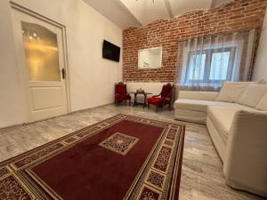 a living room with a white couch and a brick wall at Apartament Ultra Central in Sighişoara