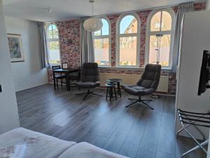 a room with chairs and a table and windows at Hotel Saint Vincent in Poeldijk