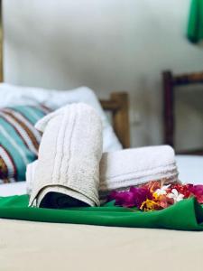 a pile of towels and a plate of flowers on a bed at Sea way in Kizimkazi +8 photos