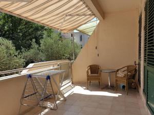 a patio with a table and chairs on a balcony at Victor Apartments in Petrovac na Moru