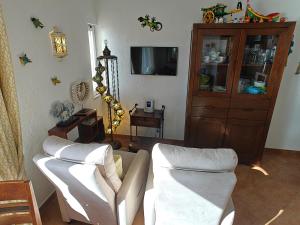 a living room with two white couches and a television at CastelloHouse, The Best Sea View, in front of Carvoeiro beach in Carvoeiro