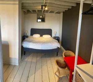 a bed in a room with two chairs and a table at Chateau Calon Segur in Durbuy