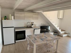 a kitchen with a table with chairs and a staircase at House on the beach Varigotti in Varigotti