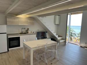 a kitchen with a table and chairs and a view of the ocean at House on the beach Varigotti in Varigotti