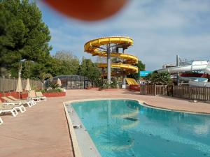 a swimming pool with a slide in a water park at Mobile home grande terrasse à Canet in Canet-en-Roussillon