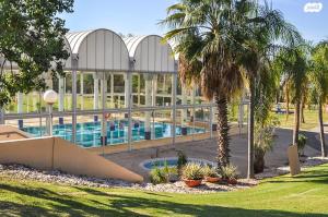 a large building with a swimming pool and palm trees at SeaView 202 in Caesarea