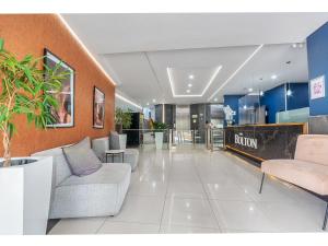 a lobby with couches and tables in a building at The Bolton serviced apartments Rosebank in Johannesburg +40 photos