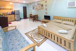 a living room with a bed and a kitchen at Aroma's Guest House in San Juan