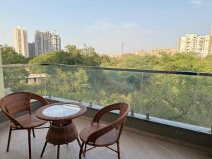 two chairs and a table on a balcony with a view at Hotel Pruthvi Executive, Pune in Pune