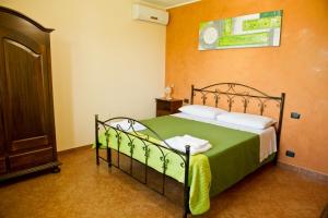 a bedroom with a bed with green sheets and white pillows at I Due Pini in Sogliano Cavour