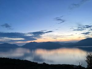 a view of a lake at sunset at Tumpseys Hideaway with Hot Tub & Sunset Loch Views, Glencoe Near Fort William in Ballachulish