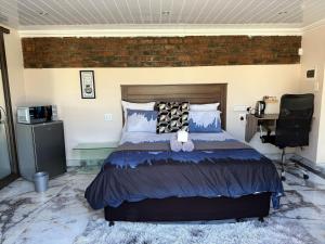 a bedroom with a bed and a desk in it at Guest House on Keam in East London +82 photos