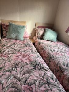 two beds sitting next to each other in a bedroom at Snowdon View, White Tower Holiday Park in Caernarfon