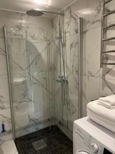 a shower with a glass door in a bathroom at Semesterlägenhet Wettervy in Gränna +31 photos