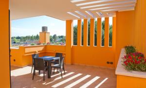 a balcony with orange walls and a table and chairs at I Due Pini in Sogliano Cavour