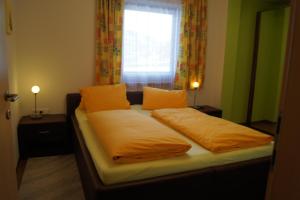 a bedroom with a bed with yellow sheets and a window at Appartement Felix in Kaprun