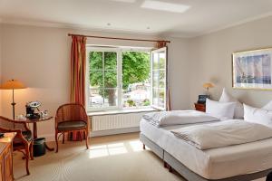 um quarto com uma cama, uma janela e uma escrivaninha em Strandhotel Strande em Strande mais 58 fotografias