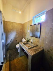 a bathroom with a sink and a toilet at Star Hill Villa in Tangalle +23 photos