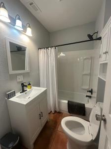 Un baño con inodoro, lavabo y ducha. en Serenity House, en Blytheville