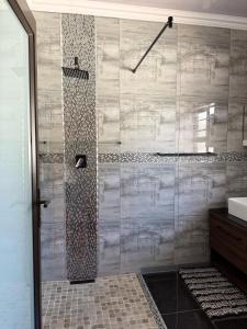 a bathroom with a shower and a sink at Guest House on Keam in East London
