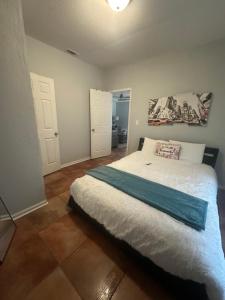 Un dormitorio con una cama grande con una manta azul. en Serenity House, en Blytheville