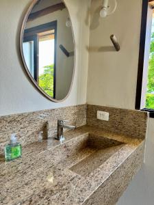 a bathroom with a sink and a mirror at Suíte com vista para o Pôr do Sol in São Sebastião
