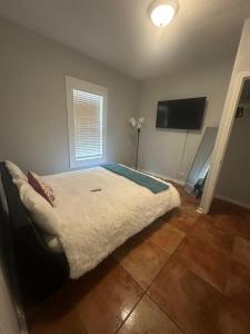 Un dormitorio con una cama y un televisor de pantalla plana. en Serenity House, en Blytheville