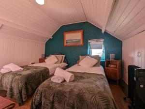 a room with two beds and a green wall at 2 Bedroom Cottage By Travel Lets Self Catering Accommodation Donegal With Sea View in Fanad