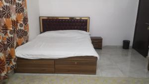 a bed with a wooden headboard in a room at سكنات قصر الياسمين in Ḩayl Āl ‘Umayr