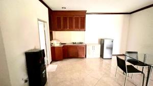 a kitchen with a table and a refrigerator at Green Kuta Apartement in Seminyak