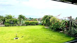 a green yard with palm trees and plants at Green Kuta Apartement in Seminyak