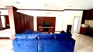 a blue couch in a living room with a television at Green Kuta Apartement in Seminyak