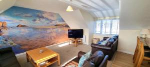 ein Wohnzimmer mit einem Gemälde des Ozeans in der Unterkunft Sand Dunes in Perranporth
