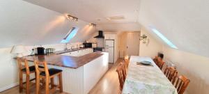 eine Küche und ein Esszimmer mit einem Tisch und einer Theke in der Unterkunft Sand Dunes in Perranporth