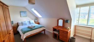 ein kleines Schlafzimmer mit einem Bett und einem Spiegel in der Unterkunft Sand Dunes in Perranporth