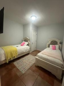 1 dormitorio con 2 camas y almohadas rosas en Serenity House, en Blytheville 4 fotos más